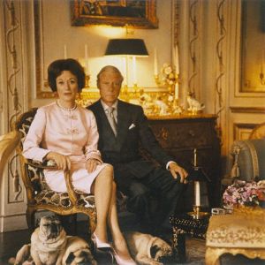 Original caption: The Duke and Duchess of Windsor, sitting in the drawing room of their Paris home, with their four Pug dogs at their feet. ca. 1964 Paris, France